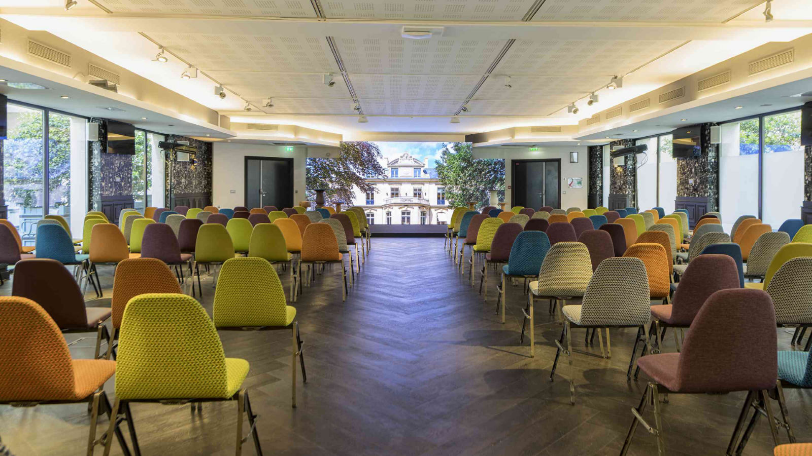 Salle de réunion parisienne moderne et colorée disposée en rangées pour une journée d'étude