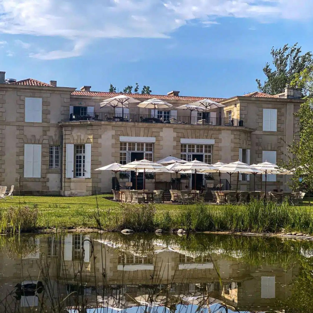 Château au bord de l'étang, terrasse aux parasols blancs